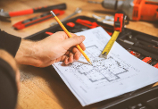 Man Working on Blueprint with Pencil and Ruler for Precision
